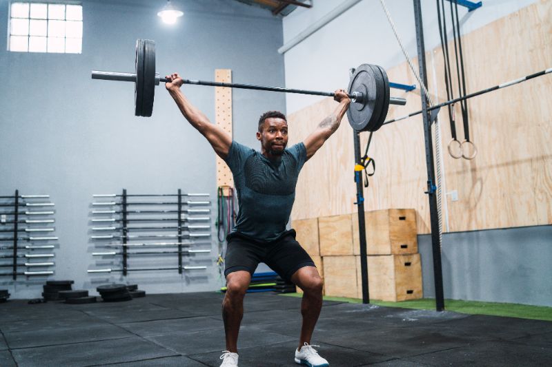 homem executando movimento crossfit snatch