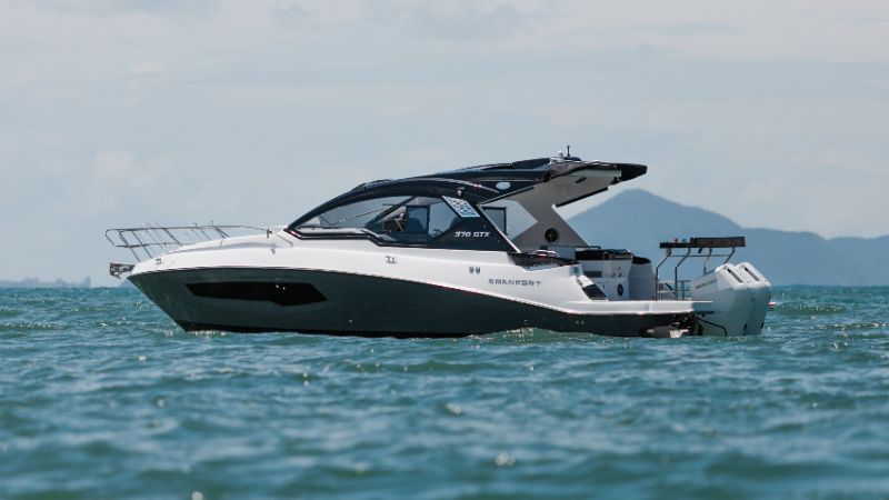 Premium Granfort 300 GTX boat docked at a modern waterfront showroom in Melbourne Florida under clear blue skies 