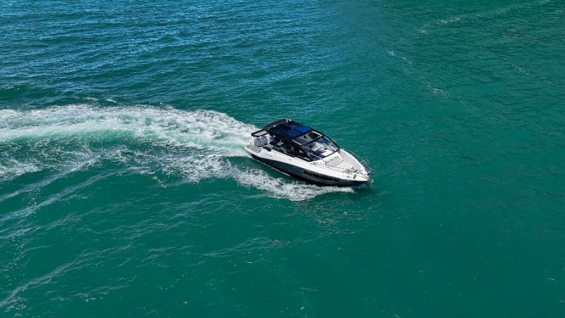 Premium motorboat cruising on clear blue water with Italian design details visible 