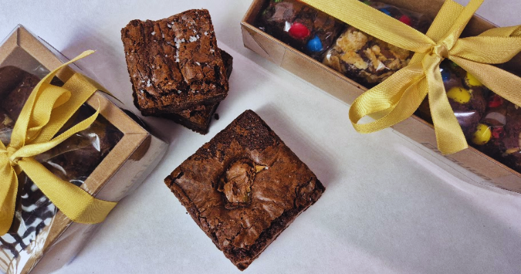 Caixas premium de brownies e cookies artesanais com embalagem personalizada em mesa de madeira rústica 
