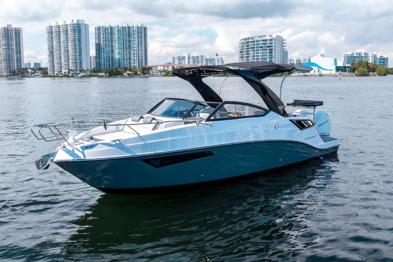 Luxury boats docked at a sunny marina with clear blue skies and calm water 