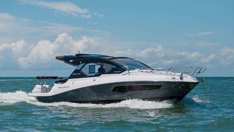 Experienced boat owner inspecting premium boat with warranty documents on dock 