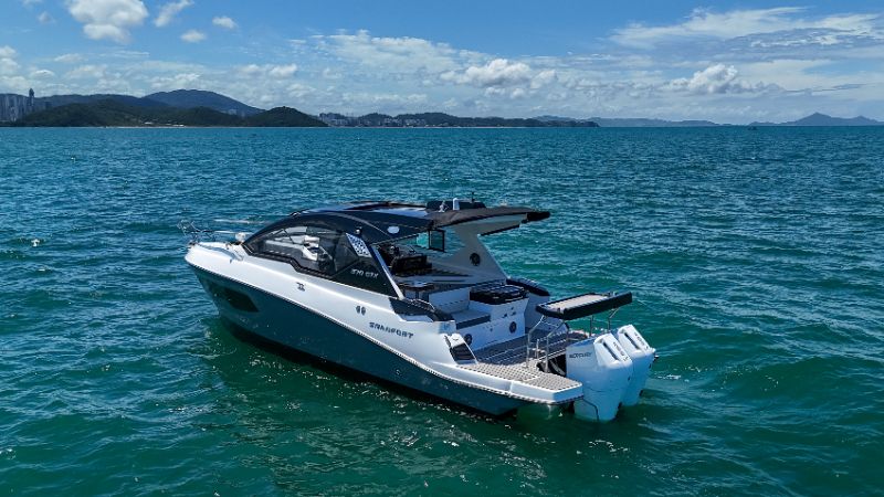 Express cruiser boat sailing on clear blue water with passengers enjoying sunlit deck and modern seating 