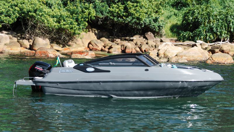 Multiple premium luxury boats docked side by side showing detailed craftsmanship and sleek designs under clear blue sky 