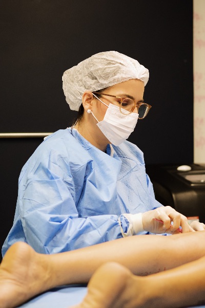 Procedimento médico com aplicação de endolaser nas pernas para tratamento de varizes, ambiente clínico moderno com equipamentos de ultrassom e laser, técnica minimamente invasiva, médico especialista 