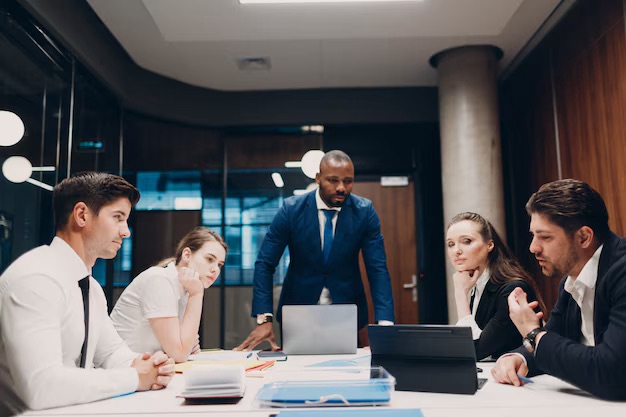 Profissionais discutindo plano de saúde empresarial com gráficos e documentos financeiros 