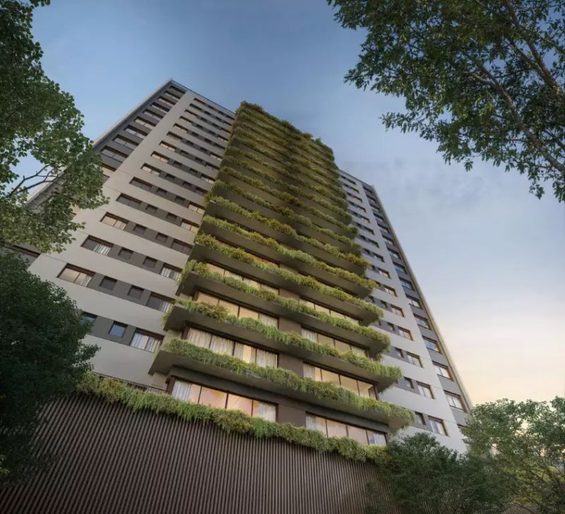 Fachada de prédio residencial de alto padrão com arquitetura moderna em área nobre, com iluminação noturna e detalhes em vidro e concreto 