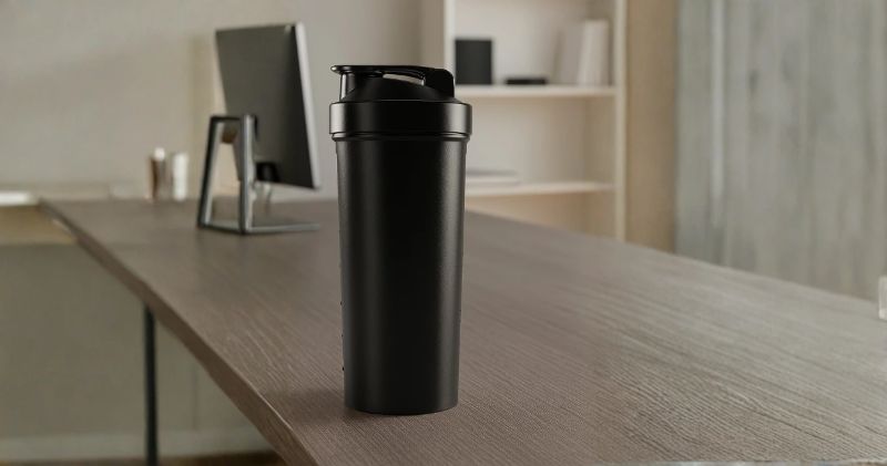 Mesa com coqueteleiras personalizadas, gráficos de sell-out e laptop com relatórios 