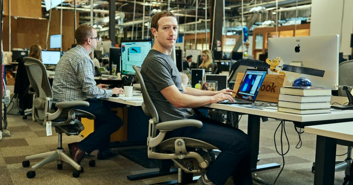 Fundadores de startup em reunião analisando estratégia de branding com post-its e laptop 