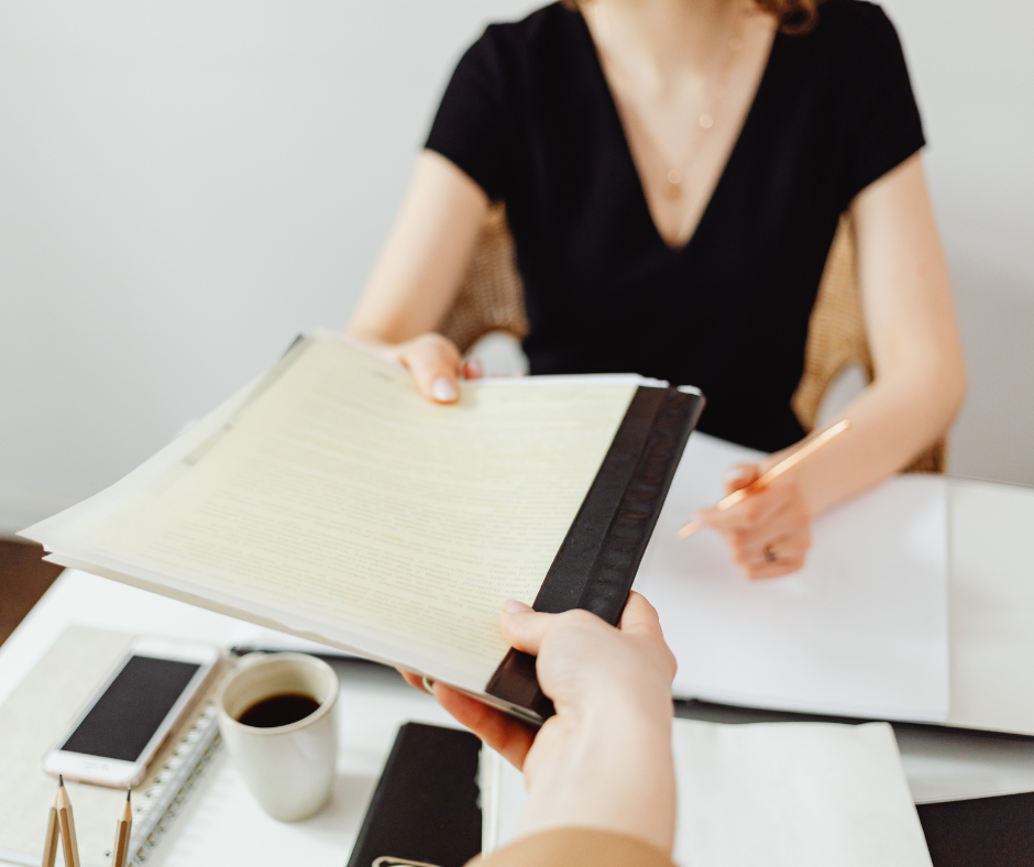 Gestora de RH entre pilha de papéis e painel de sistema digital em escritório 