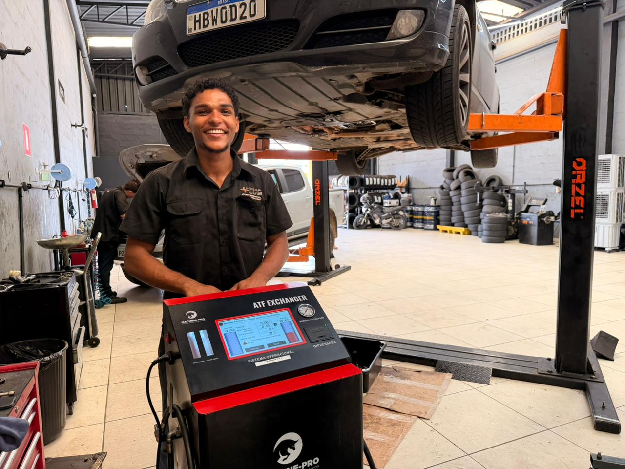 Mecânico verifica nível do óleo do câmbio automático de um carro moderno 