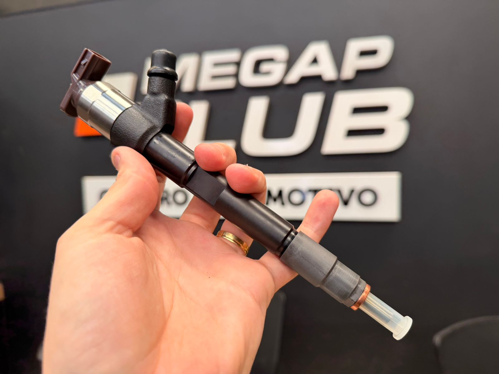 Close-up de bico injetor diesel desmontado em bancada limpa de oficina 