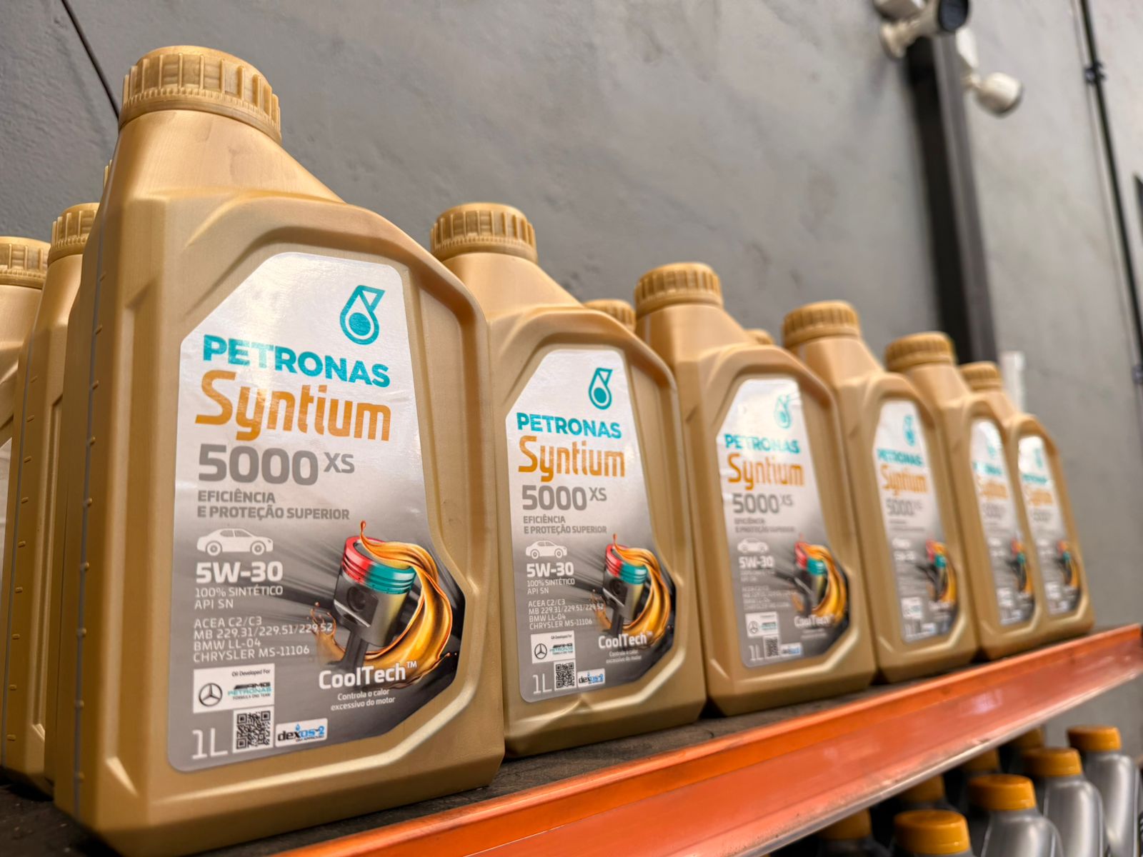 Carro sobre rampa em oficina com painel digital indicando troca de óleo 