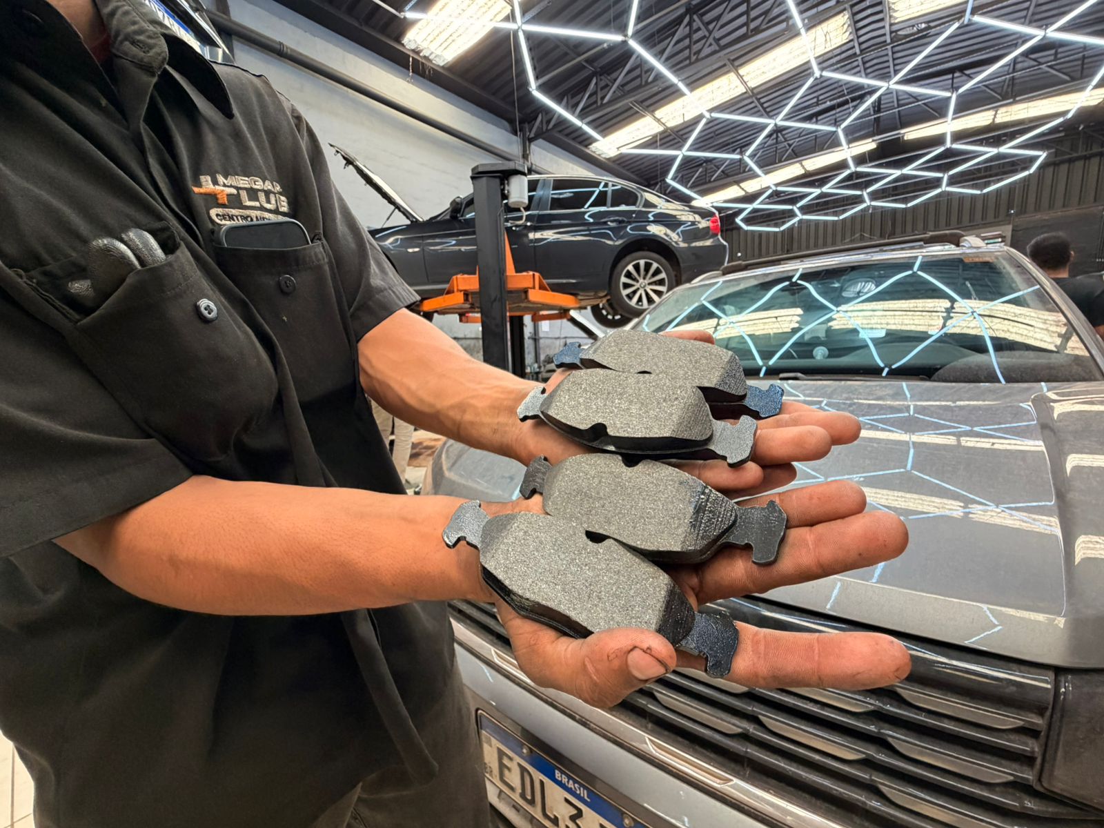 Detalhe de pastilha de freio gasta ao lado de disco com sulcos 