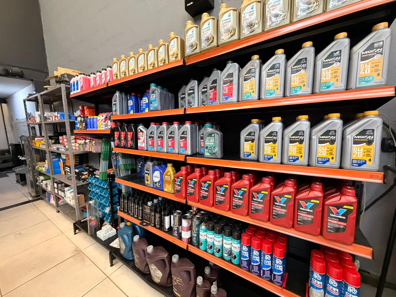 Mecânico checando checklist de revisão preventiva ao lado de carro em oficina moderna 