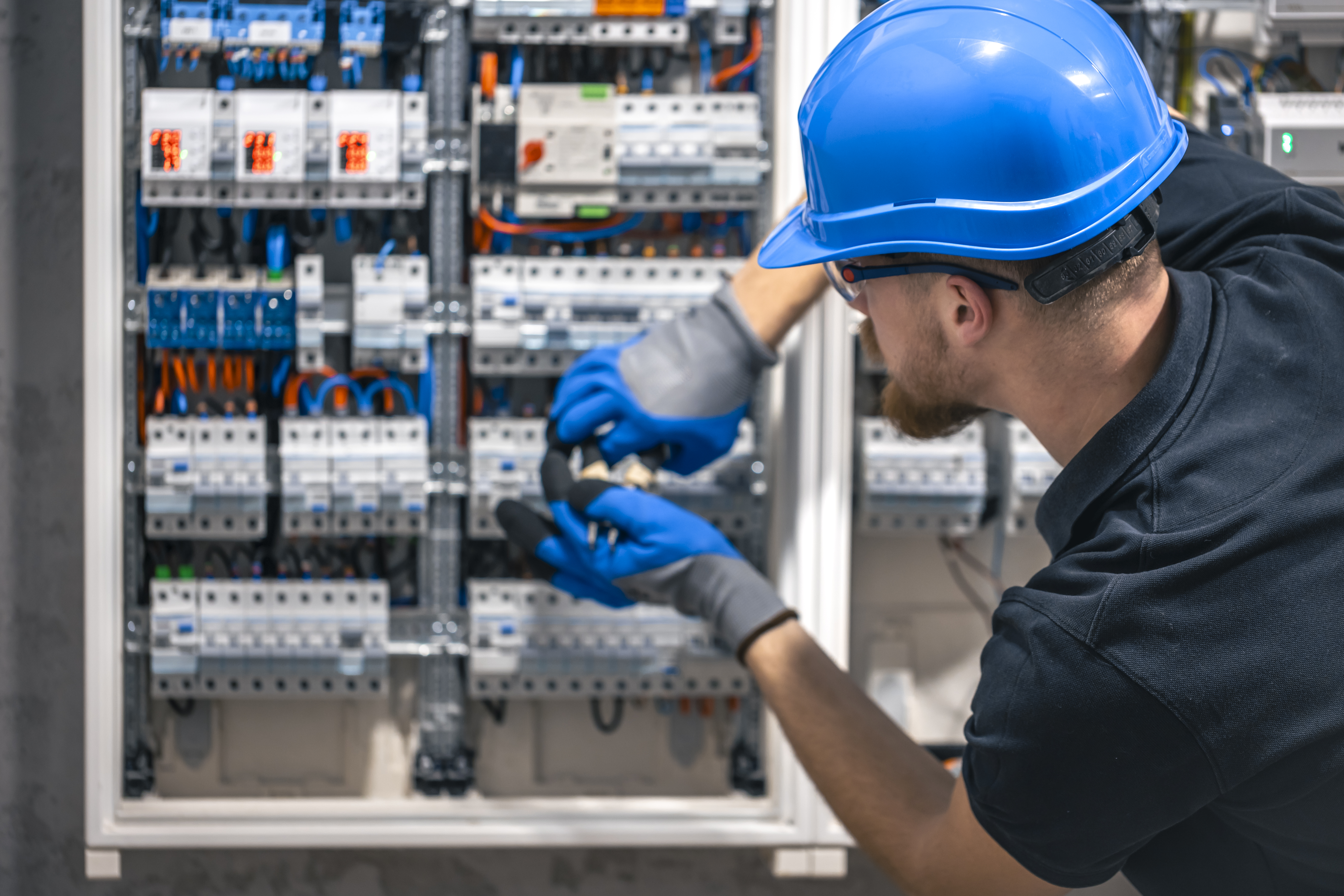Engenheiro inspecionando painel elétrico em sala crítica de data center 