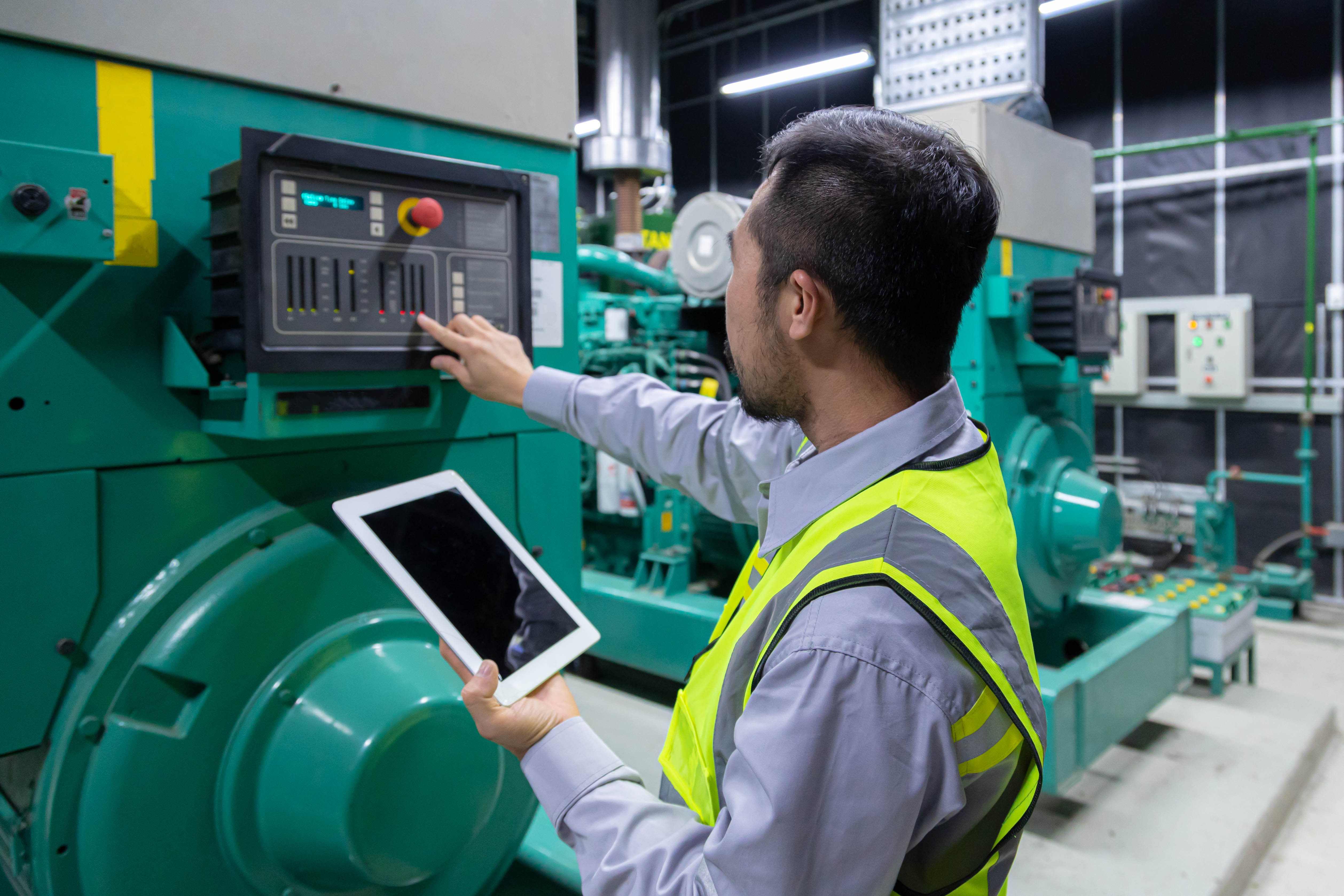Engenheiro analisando painel digital de manutenção preditiva em sala de controle industrial 