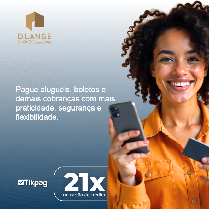 Jovem sentado em sofá fazendo pagamento de aluguel parcelado no cartão de crédito pelo notebook 
